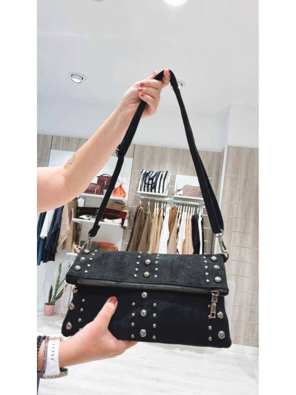 Bolso Triana negro con tachuelas metálicas, estilo bandolera moderno y atrevido.